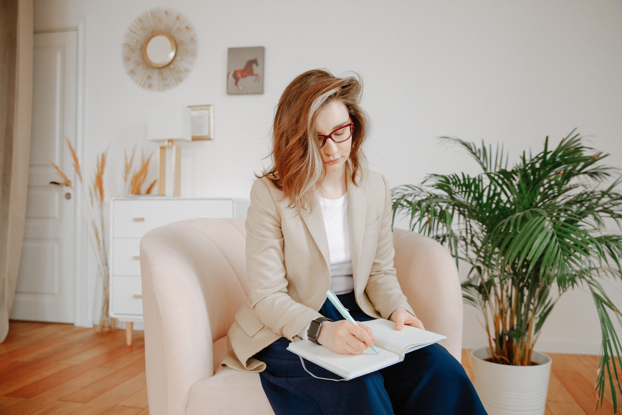 female criminal psychologist sitting on a chair and writing notes in her book